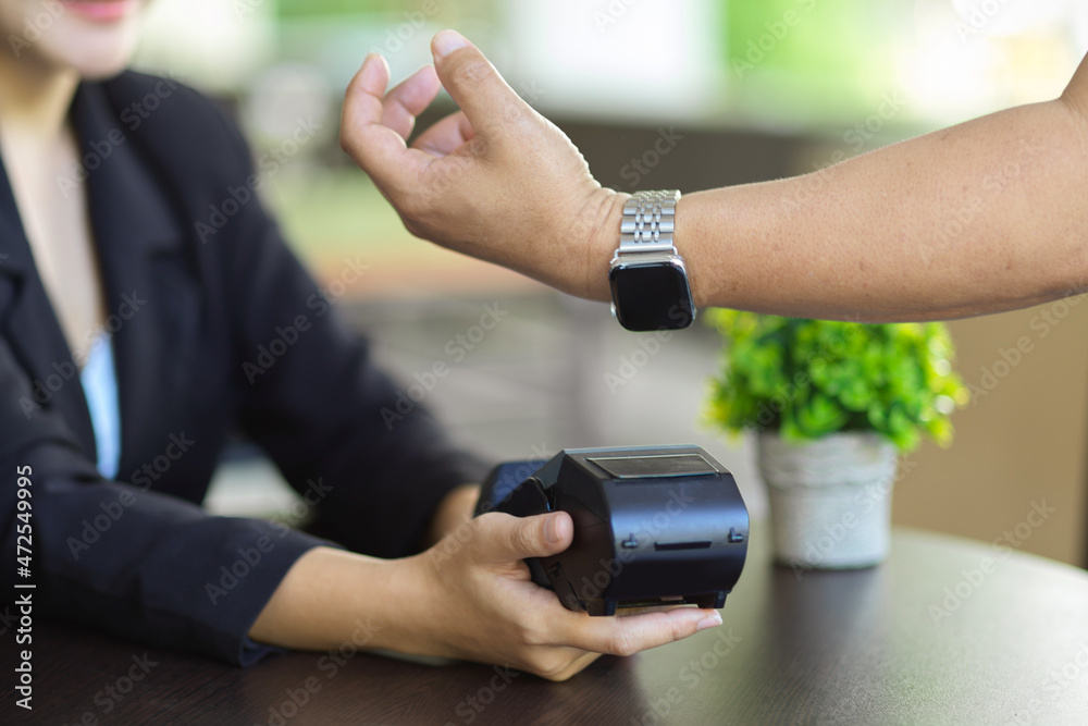 a man using his modern smartwatch to pay on online payments
