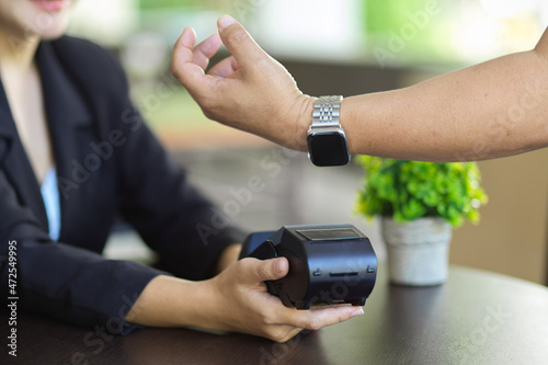 a man using his modern smartwatch to pay on online payments