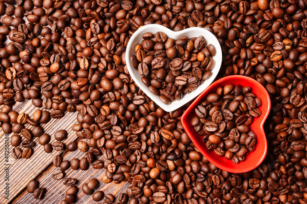 Fototapeta premium Horizontal background heart and coffee beans on a wooden table. Good morning coffee lover.