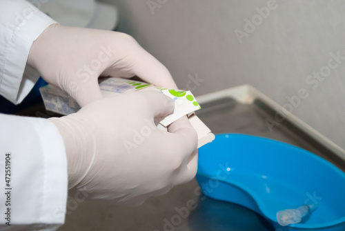 doctor in medical gloves opens a box of medicine before vaccination against coronavirus covid 19