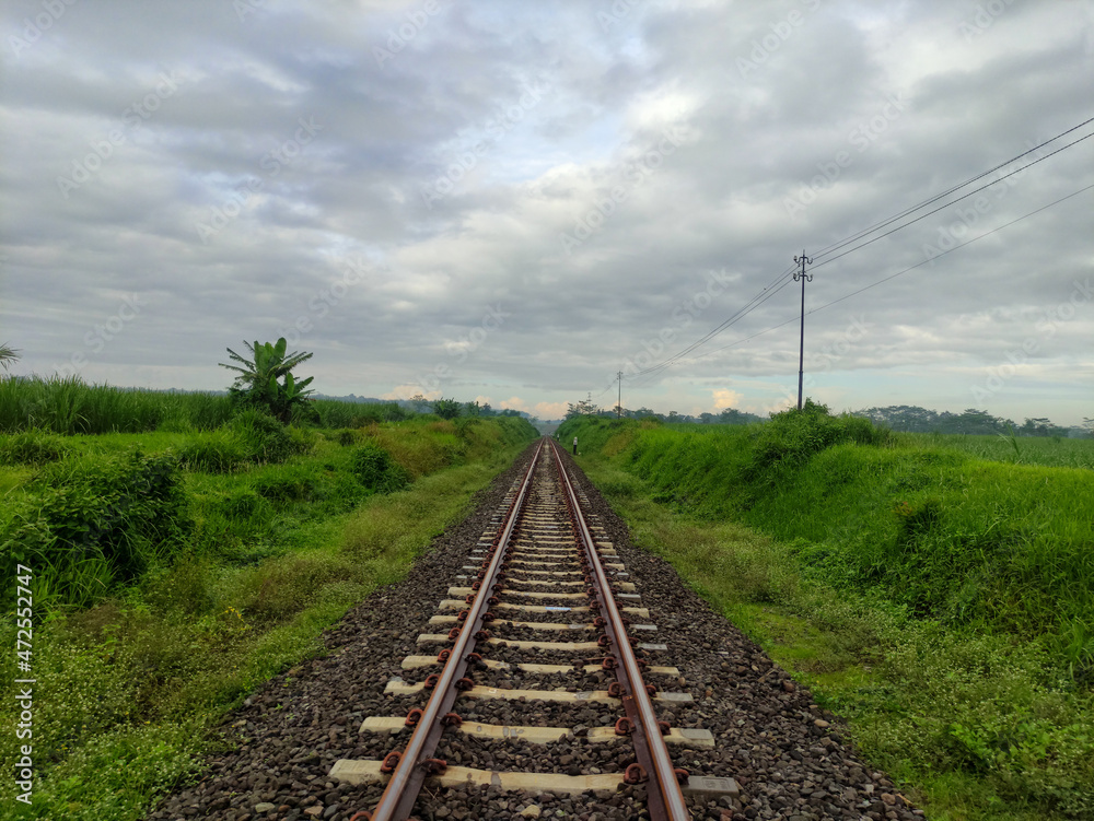 railroad track near green countryside