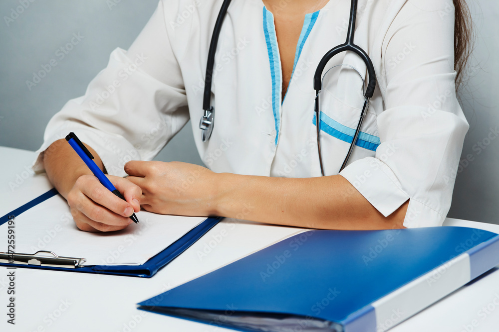 Female doctor working at office desk on white background, close-up