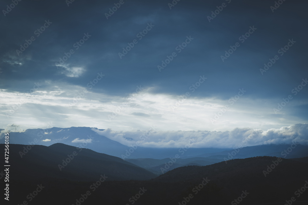 Obraz premium Panorama of mountains with a beautiful dramatic sky, clouds and sunlight.