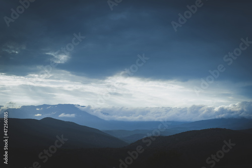Panorama of mountains with a beautiful dramatic sky, clouds and sunlight.