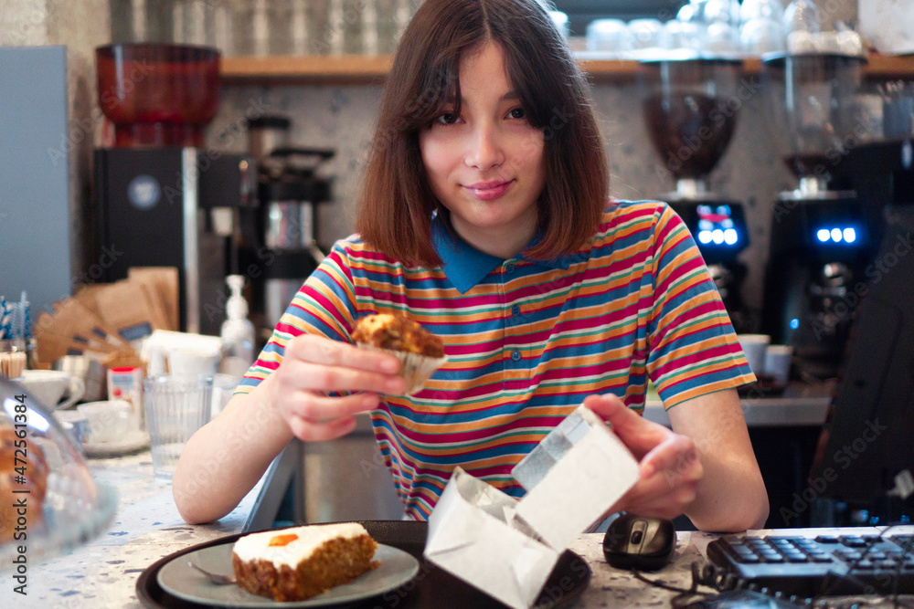A cute bar waitress is packing the pastries. A cute bar waitress is packing the pastries.