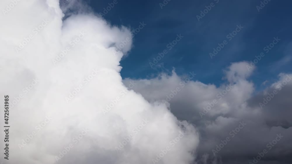 Aerial view from airplane window at high altitude of earth covered with puffy cumulus clouds forming before rainstorm Aerial view from airplane window at high altitude of earth covered with puffy cumulus clouds forming before rainstorm
