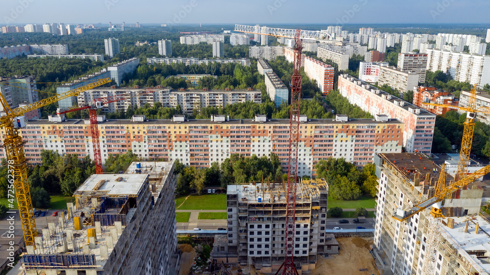 New high-rise apartment buildings under construction. Aerial photo at sunny evening