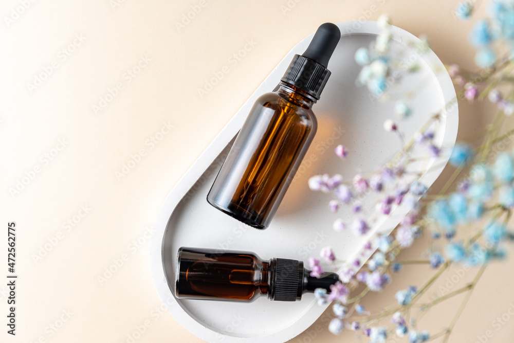top view of two dark glass pipette bottles with essential oil and collagen for skin care. Unbranded package with copy space. Designers mokup top view of two dark glass pipette bottles with essential oil and collagen for skin care. Unbranded package with copy space. Designers mokup