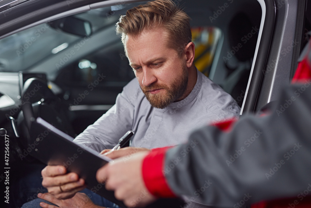 Car mechanic and client with report on clipboard Car mechanic and client with report on clipboard