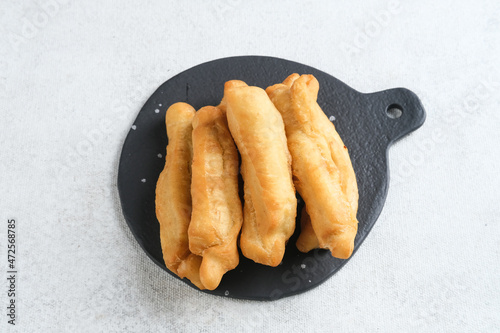 Cakwe or Cakue or Youtiao is traditional Chinese snack, long golden-brown deep-fried strip of dough and very popular in China and Asia. Selective focus image, copy space.
 photo