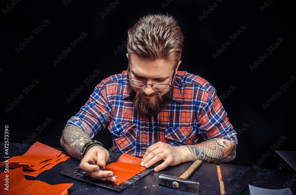 Artist working with leather working with leather using crafting tools