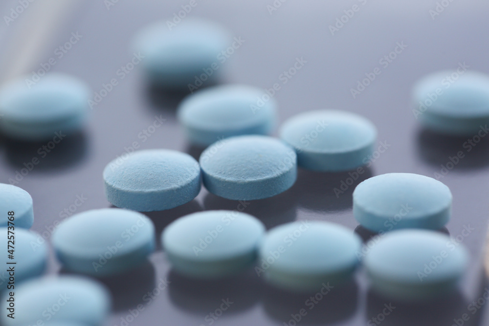 A set of blue pills on the table, close-up, shadow A set of blue pills on the table, close-up, shadow
