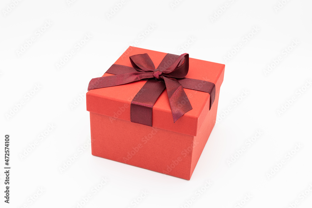 A red gift box wrapped in a red ribbon. A red gift box wrapped in a red ribbon.