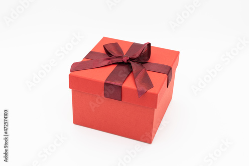 A red gift box wrapped in a red ribbon. © Jun