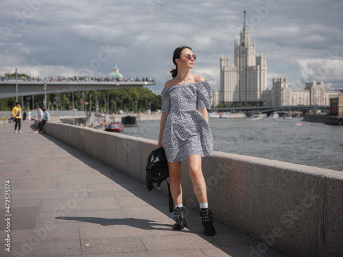 Canvas Print Beautiful woman walks on street at Moscow City sunny summer day.