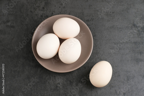 Fresh chicken eggs ( Telur Ayam Kampung ). White eggs served in small plate with copy space. Selective focus image. 