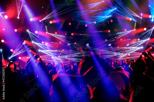 Crowd of people on the dance floor pink and blue lights