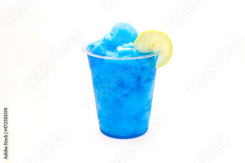 Electric blue lagoon slush lemonade with a slice of lemon in a disposable cup. photo