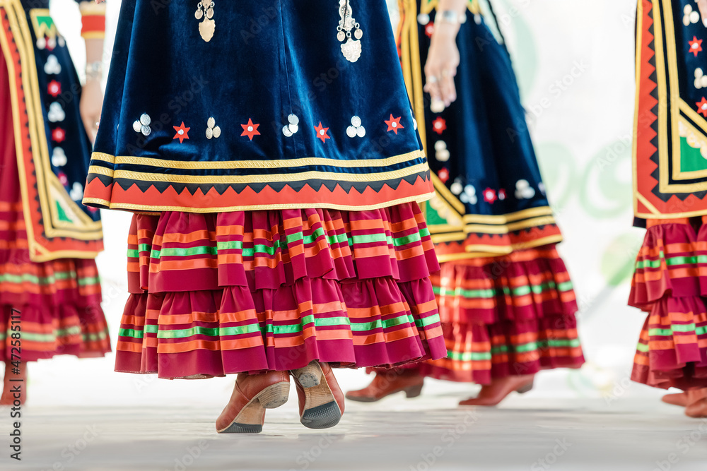 Decorated traditional Bashkir skirt flutters in folds during the dance with spinning red boots in the foreground