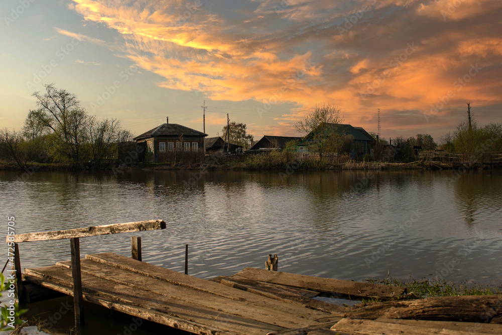 Fototapeta premium Colorful evening by the river in the village
