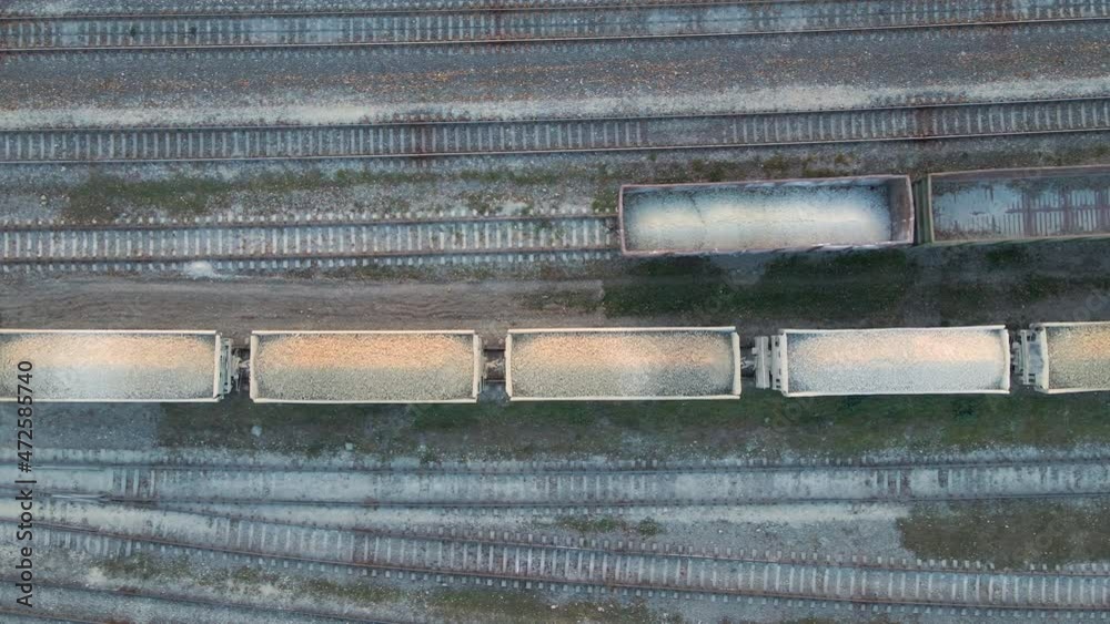 Aerial view of cargo train loaded with crushed stone materials at mining factory. Railway transportation of grinded limestone ore Aerial view of cargo train loaded with crushed stone materials at mining factory. Railway transportation of grinded limestone ore