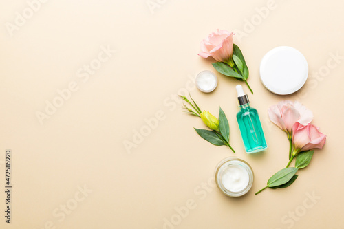 Composition with cosmetic products and beautiful roses on color background. Copy space, flat lay