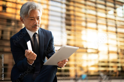 Senior businessman with digital tablet. Man holding credit card..