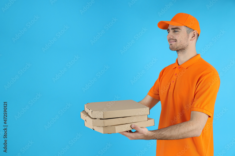 Delivery man holds pizza on blue background Delivery man holds pizza on blue background