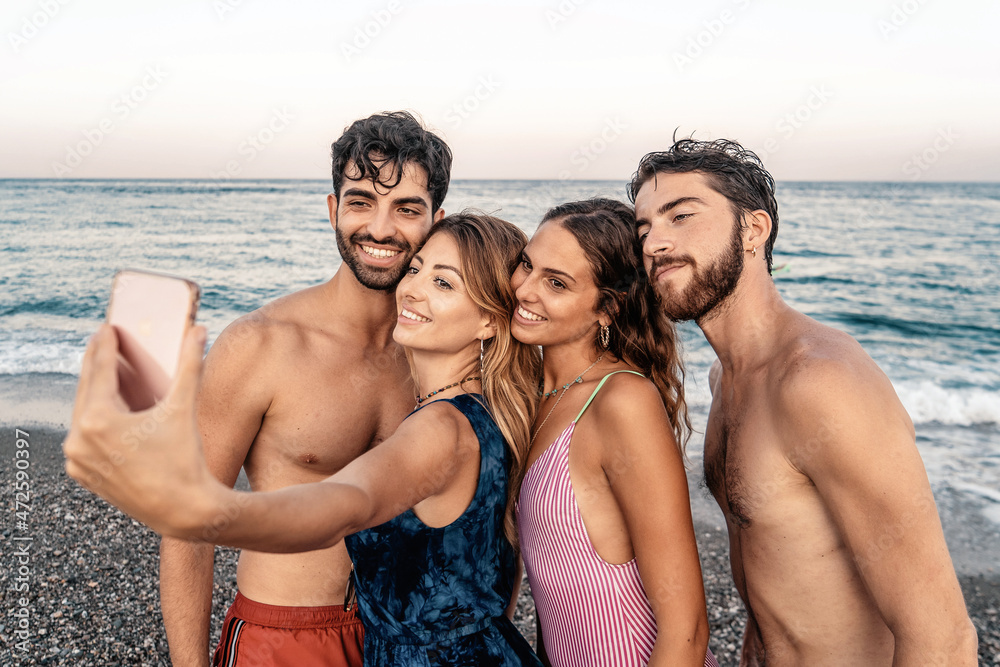 Group of friends taking selfie on beach. Best friends standing along the ocean and taking a self portrait with smart phone. Group of friends taking selfie on beach. Best friends standing along the ocean and taking a self portrait with smart phone.