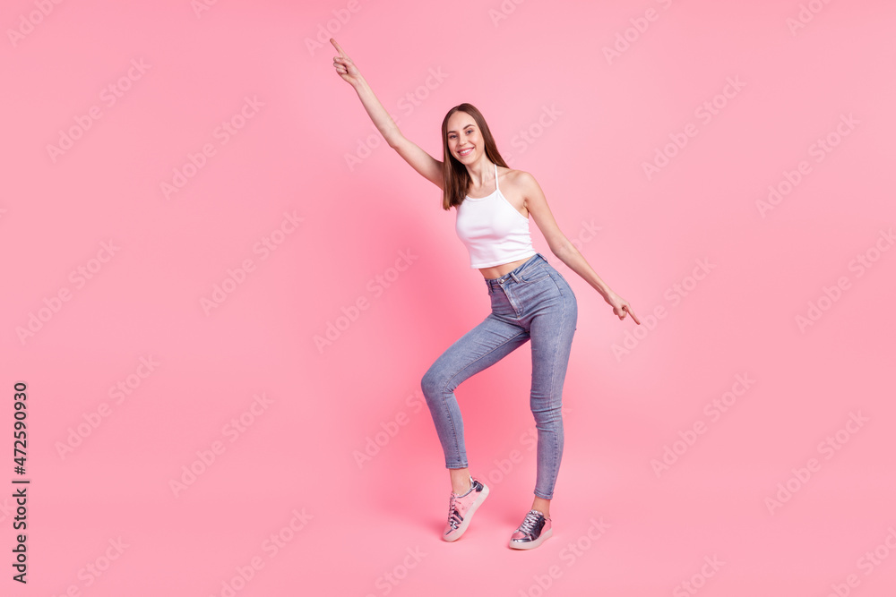 Full body photo of young cheerful girl indicate fingers empty space modern clothes isolated over pink color background