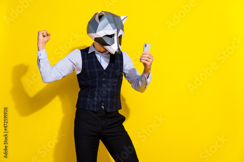 Photo of successful guy hold telephone positive feedback reaction wear raccoon mask vest isolated yellow color background © deagreez