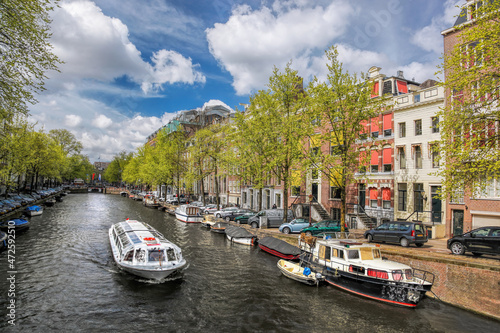 Photography Amsterdam city with tourist boats on canal during springtime in Netherlands