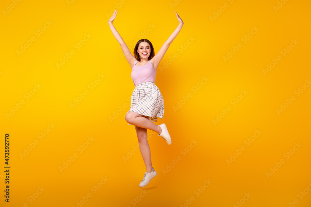 Full body photo of youth lovely lady have fun jump up wear casual clothes isolated over yellow color background Full body photo of youth lovely lady have fun jump up wear casual clothes isolated over yellow color background