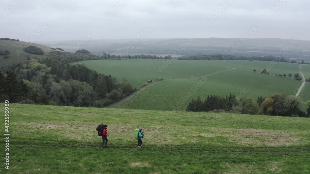 Hikers walking on the South Downs Way national trail in England. Tracking drone shot Hikers walking on the South Downs Way national trail in England. Tracking drone shot