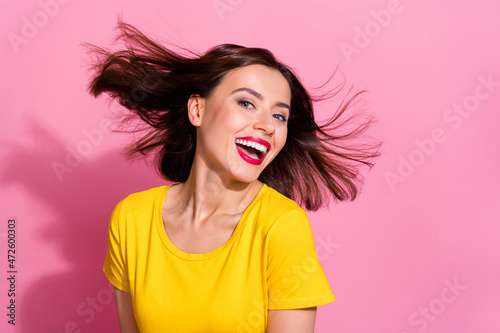 Photo of cute adorable young lady dressed yellow clothes smiling wind blowing isolated pink color background
