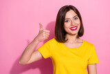 Portrait of attractive cheerful girl wear yellow t shirt showing thumbup solution isolated over pink pastel color background