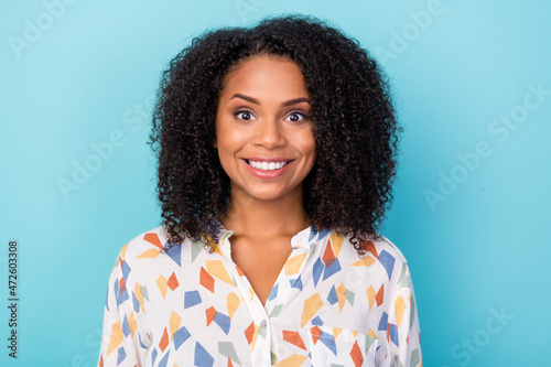 Photo of optimistic young curly hairdo lady wear white shirt isolated on blue color background