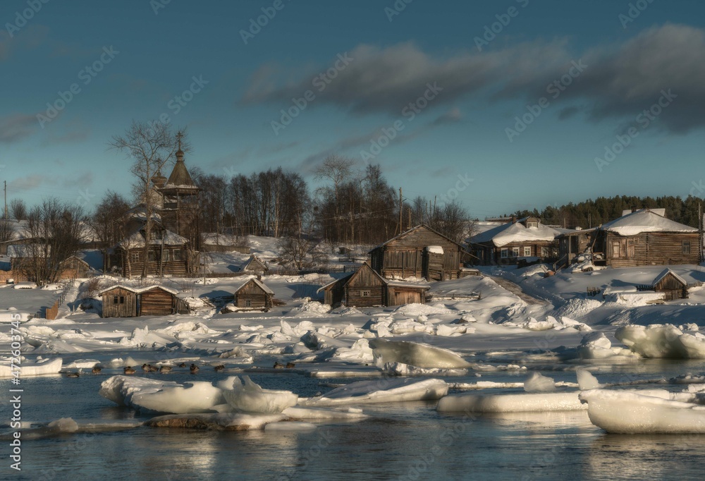 Winter old beautiful village by the river