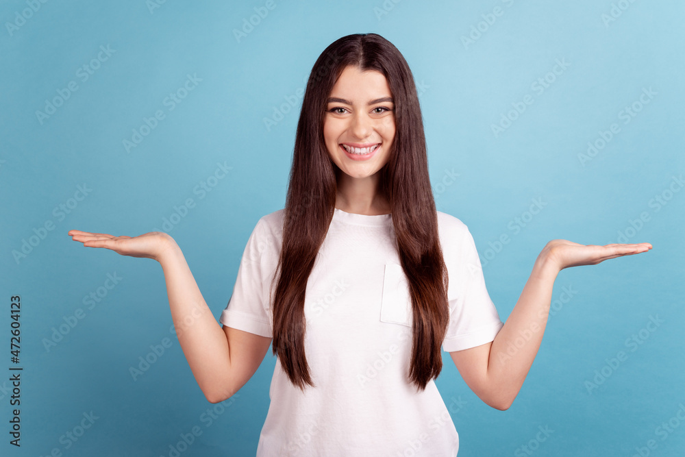 Photo of young girl hold palms recomend vs scales solution demonstrating proposition isolated over blue color background Photo of young girl hold palms recomend vs scales solution demonstrating proposition isolated over blue color background