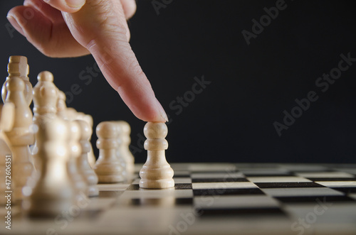 Male hand moving chess piece strategy