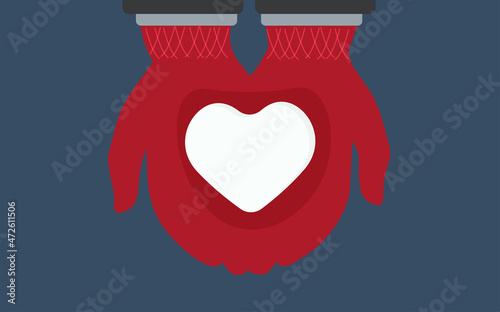 Hands hold a heart made of snow.Winter mood.Warm mittens