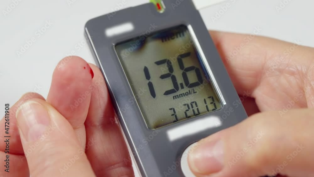 Diabetic checking their blood glucose levels on a glucometer Diabetic checking their blood glucose levels on a glucometer