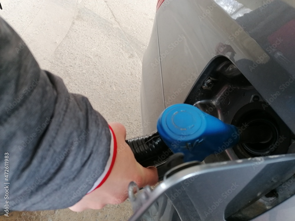 Man at the gas station with a hose in her hand and fills the car with gasoline. Man at the gas station with a hose in her hand and fills the car with gasoline.