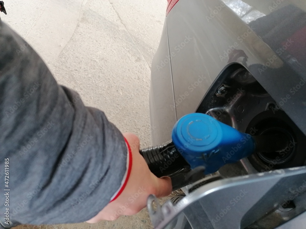 Guy pouring fuel in vehicle at the gas station