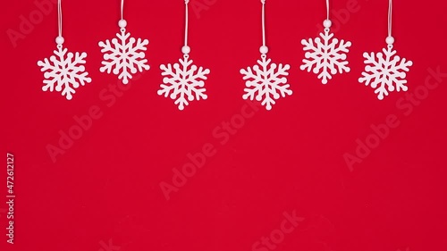 Hanging snowflakes on red theme. Christmas decorations stop motion