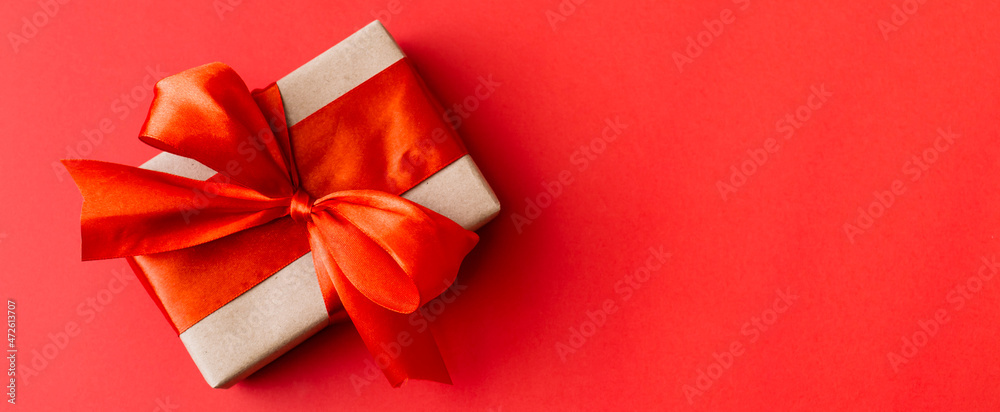 Banner made of Present box with red bow on red background. Flat lay, top view, copy space. Banner made of Present box with red bow on red background. Flat lay, top view, copy space.