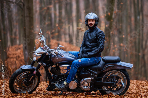 Handsome biker in the forest in autumn. © czamfir