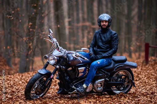 Handsome biker in the forest in autumn. © czamfir