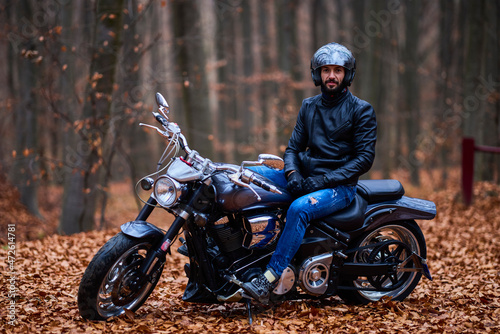 Fototapeta Naklejka Na Ścianę i Meble -  Handsome biker in the forest in autumn.