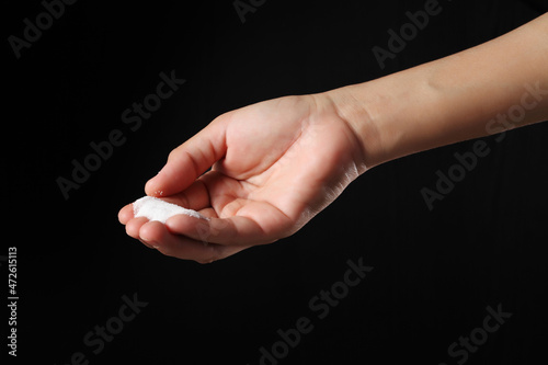Hand holding salt on black background
